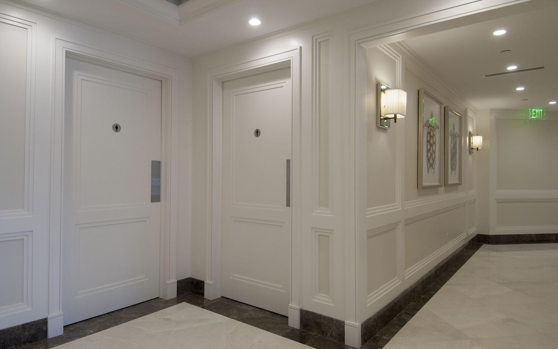Custom restroom doors designed to match existing millwork