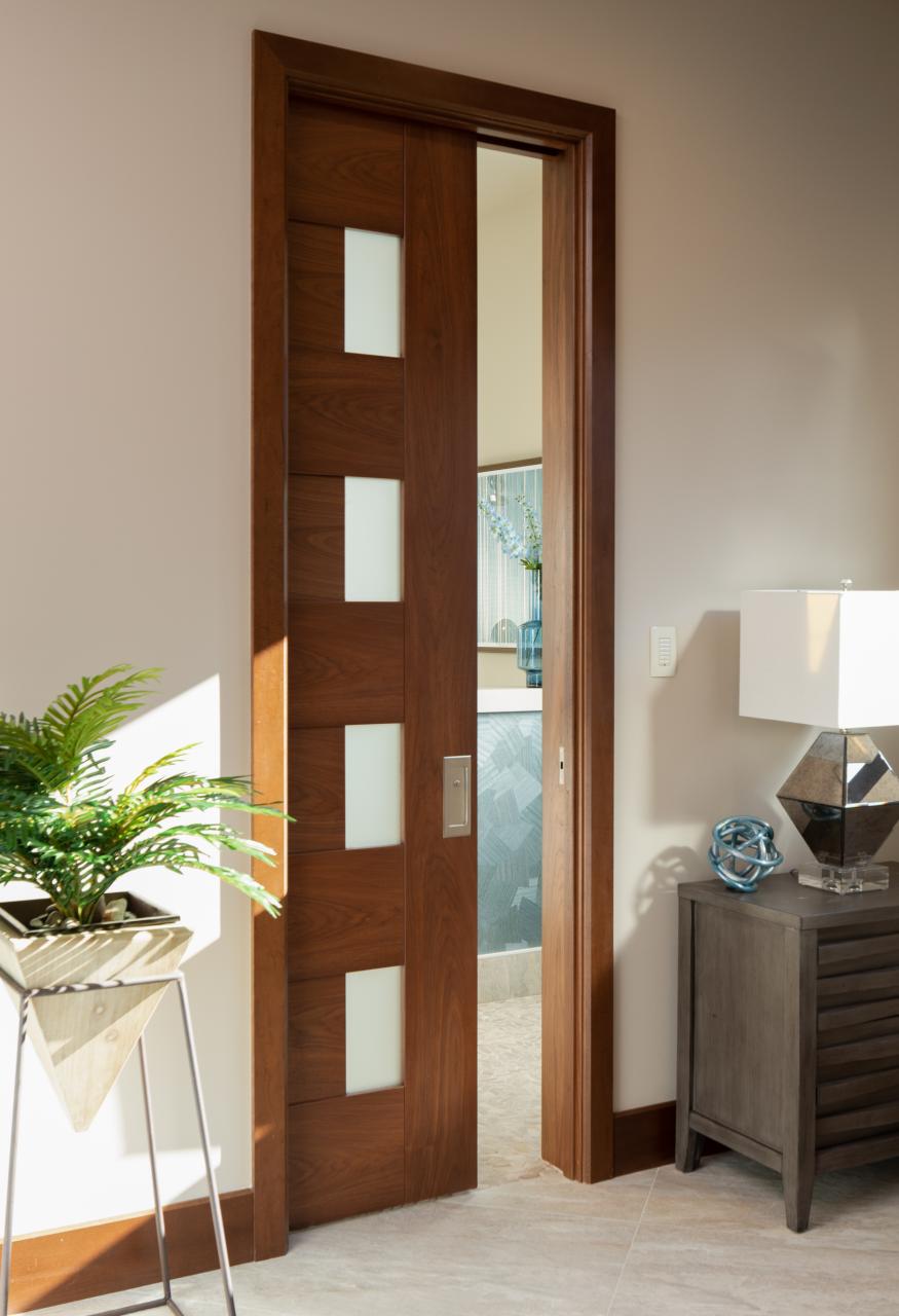A TM9400 door, in walnut with Nutmeg stain and Frosted glass, divides the bathroom from the rest of this guest suite